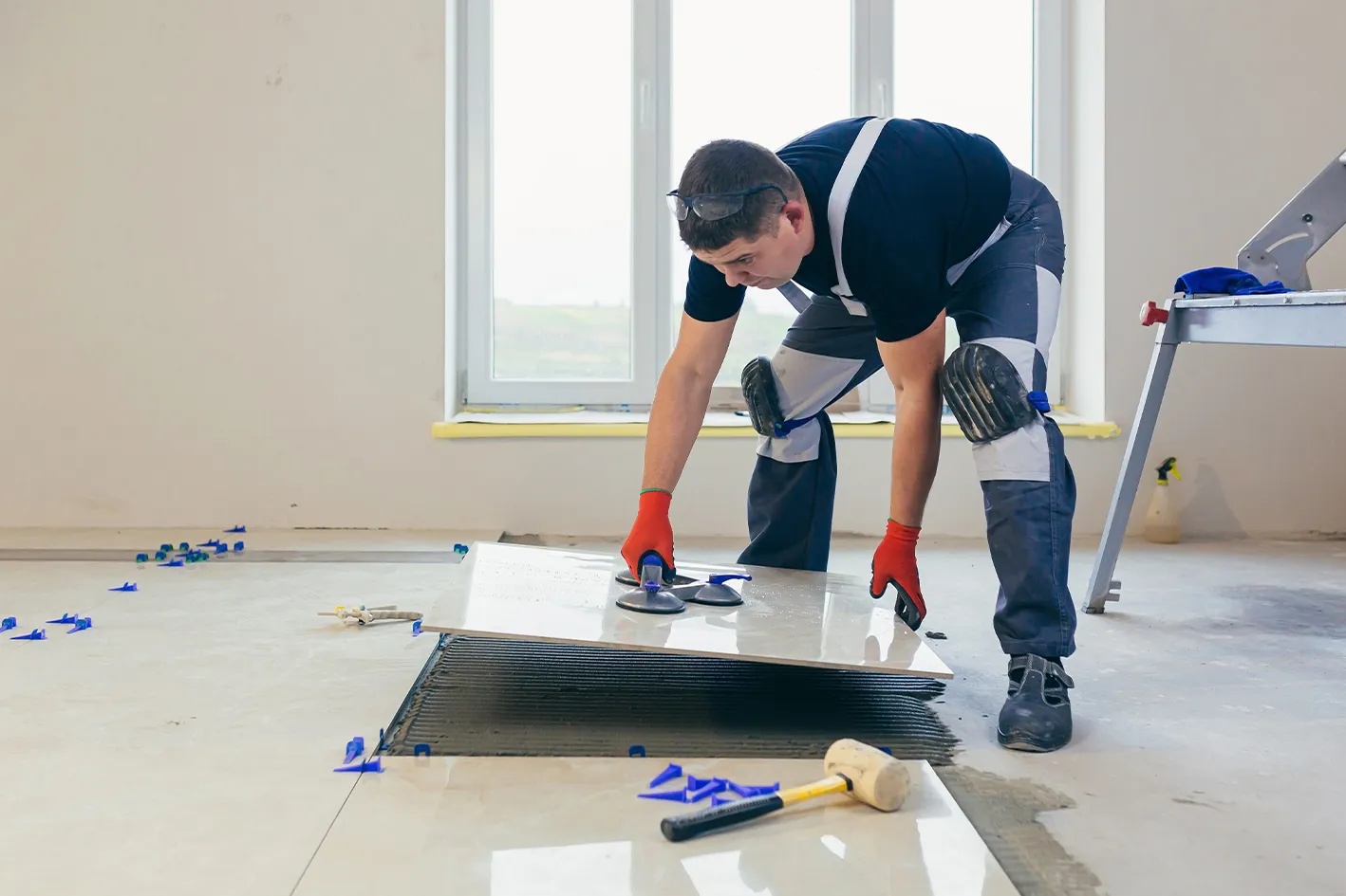 Tiler setting a large-format ceramic tile during a bathroom installation