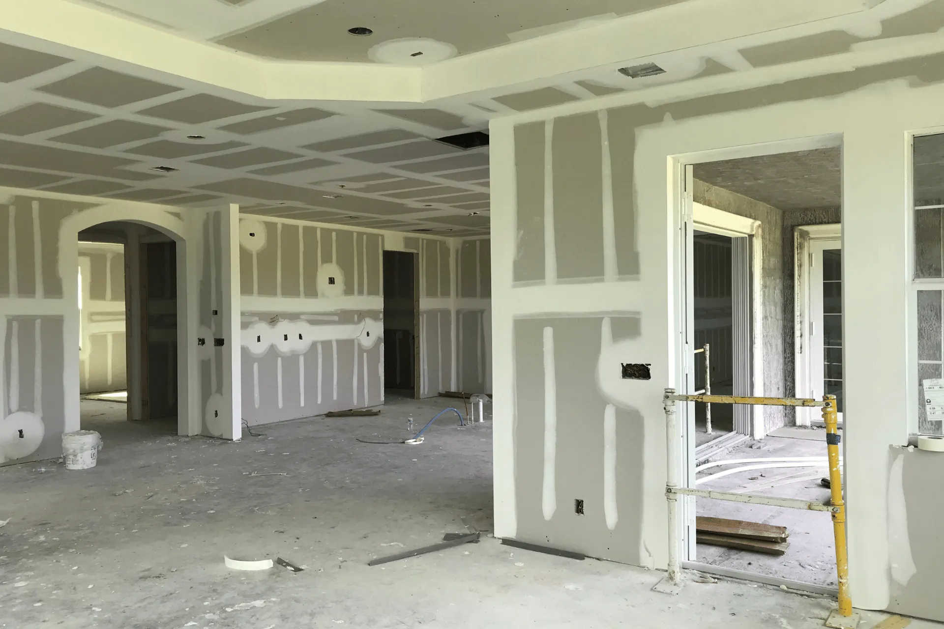 Interior space with drywall hung and seams taped, ready for the finishing coats