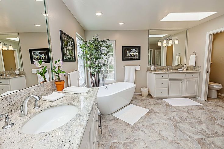 Finished bathroom with a freestanding bath, tiled surround and fitted vanity units