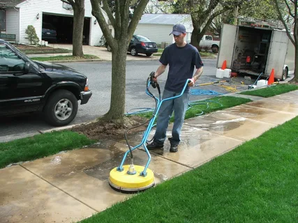 Rotary surface cleaner producing an even clean line across a concrete driveway